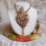 Collier L’Oiseau des Iles brodé façon Art Nouveau sur une suédine avec une estampe où se niche différents cristaux de tailles et couleurs différentes, des rocailles Miyuki et des perles Antiques 